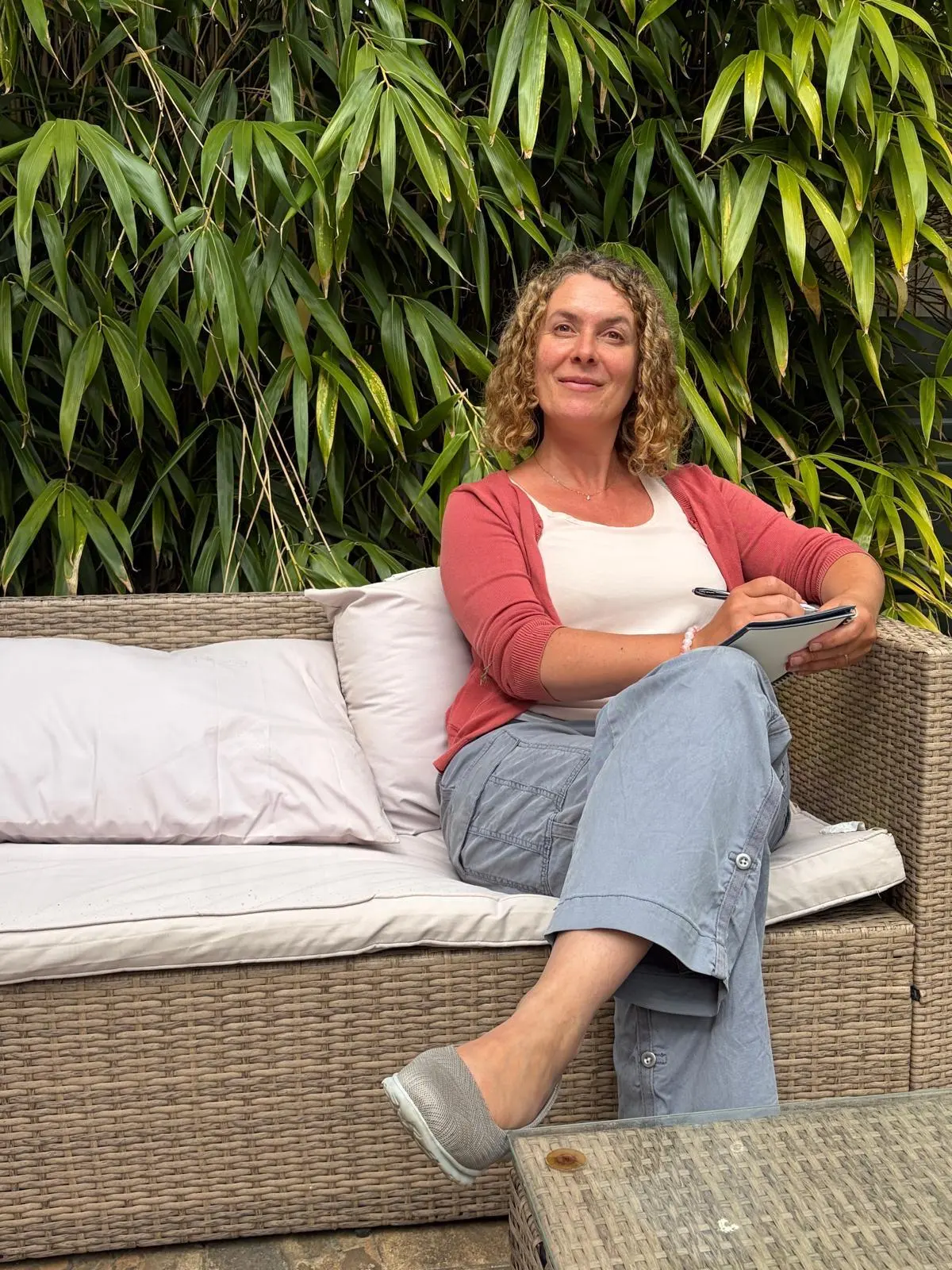 Natalia, menopause nutritionist, surrounded by greenery, reflecting and planning calmly